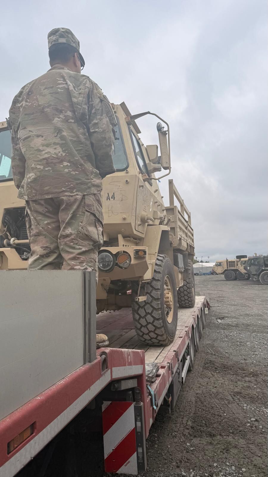Soldier guiding a tactical truck onto a trailer