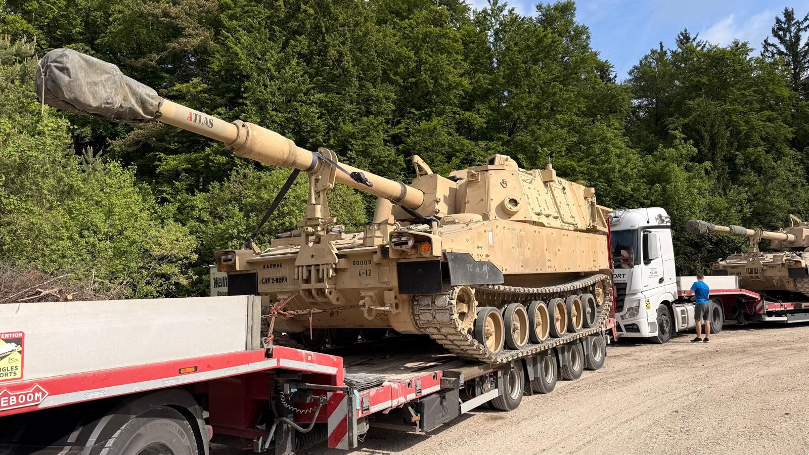 Self-propelled howitzer secured on a lowloader trailer
